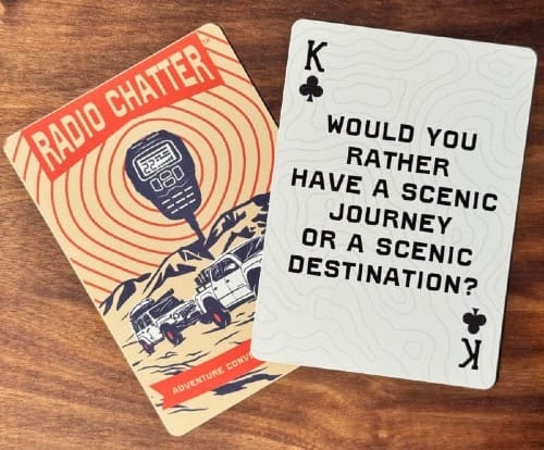 picture of two playing cards, one with the picture of two vehicles off-roading and the other a King of Clubs with the question 'Would you rather have a scenic journey or a scenic destination."